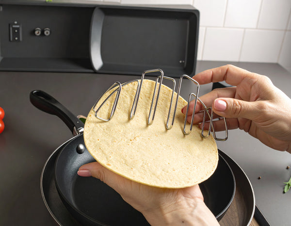 Tortilla placed around the taco metal shaper ready to be folded